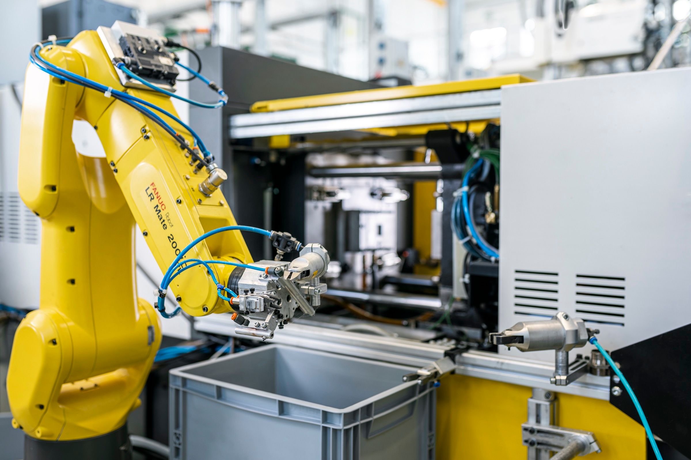 Industrieroboter beim Teilehandling an einer Spritzgussmaschine